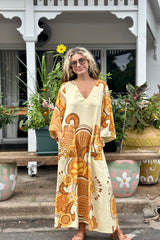 70s inspired maxi kaftan-style dress with bell sleeves , retro patch pockets and a v-neckline. Features a bold, large-scale  retro geo print. in rich mustard and brown tones. Made in 100% cotton
