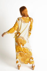 Back view of our 70s inspired maxi kaftan-style dress with bell sleeves , retro patch pockets and a v-neckline. Features a bold, large-scale  retro geo print. in rich mustard and brown tones. Made in 100% cotton