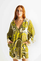 60s inspired mini smock dress with bell sleeves, patch pockets and a v-neckline. Features a bold, large-scale retro geo print. in rich green tones. Made in 100% cotton