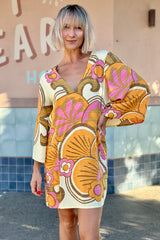60s inspired mini smock dress with bell sleeves and a v-neckline. Features a bold, large-scale tangerine, pink and brown retro geo print. Made in 100% cotton