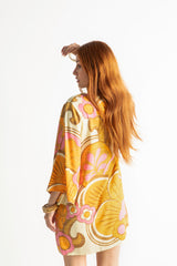 60s inspired mini smock dress with bell sleeves and a v-neckline. Features a bold, large-scale tangerine, pink and brown retro geo print. Made in 100% cotton