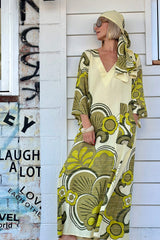 70s inspired maxi kaftan-style dress with bell sleeves , retro patch pockets and a v-neckline. Features a bold, large-scale  retro geo print. in rich green tones. Made in 100% cotton