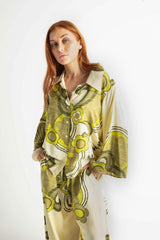 70s style button-up top with a stament retro collar and bell sleeves, featuring a bold large-scale floral print in rich green and cream tones, crafted from 100% rayon for a soft, flowing fit.