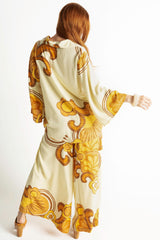 Back view of our 70s style top and pants set in a bold large scale retro floral print in rich mustard and cream tones. Made in 100% rayon