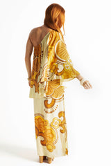 Bohemian style one shoulder maxi dress featuring a long, flowy frill that covers one arm and drapes elegantly down to the hips. This dress has side splits and showcases a large-scale bold, retro inspired print in rich mustard, brown and cream tones. Made in 100% rayon.