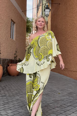 Bohemian style one shoulder maxi dress featuring a long, flowy frill that covers one arm and drapes elegantly down to the hips. This dress has side splits and showcases a large-scale bold, retro inspired print in rich green and cream tones. Made in 100% rayon.