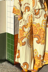 Elasticated wide leg pants with pockets in a bold large scale retro floral print in rich mustard and cream tones. Made in 100% rayon