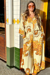 70s style top and pants set in a bold large scale retro floral print in rich mustard and cream tones. Made in 100% rayon