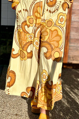 Elasticated wide leg pants with pockets in a bold large scale retro floral print in rich mustard and cream tones. Made in 100% rayon
