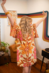 Vintage inspired bohemian style button up smock dress in a large scale floral print in pink and orange with a buttery cream background