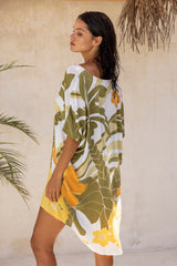 Large scale retro palm print flowy summer resortwear kaftan dress with round neckline batwing style 3/4 sleeves and drapes longer at the back 100% rayon black magenta and aqua colourway with colourful bangles to compliment