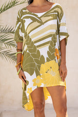 Large scale retro palm print flowy summer resort wear kaftan dress with round neckline batwing style 3/4 sleeves and drapes longer at the back 100% rayon olive green colourway with colourful bangles to compliment