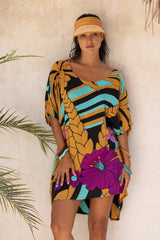 Large scale retro palm print flowy summer resortwear kaftan dress with round neckline batwing style 3/4 sleeves and drapes longer at the back 100% rayon black magenta and aqua colourway with colourful bangles to compliment