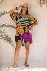 Large scale retro palm print flowy summer resortwear kaftan dress with round neckline batwing style 3/4 sleeves and drapes longer at the back 100% rayon black magenta and aqua colourway with colourful bangles to compliment