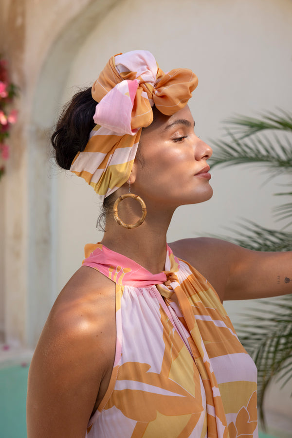 Large scale retro palm print 70s style head wrap tied up in a top notch with bamboo hoops earrings to compliment flamingo pink colourway 100% rayon