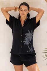 With an oversized 70s retro collar this button up terry towelling shirt with coconut buttons gives full 70s vibes. Worn with the matching shorts it's the perfect retro shirt and shorts set. Black with hand screen palm print. Cotton / elastane blend