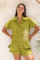 With and oversized 70s retro collar this button up terry towelling shirt gives full 70s vibes. Worn with the matching shorts it's the perfect retro shirt and shorts set. Olive green with hand screen palm print. Cotton / elastane blend