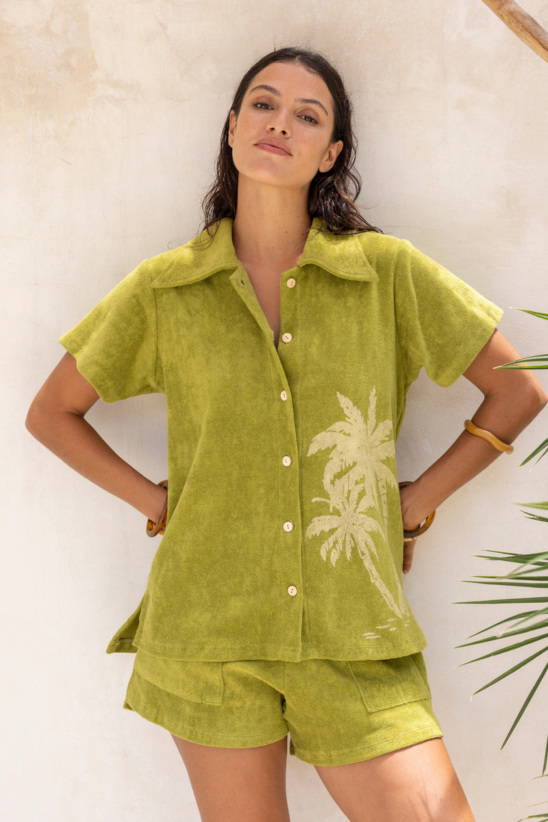 With and oversized 70s retro collar this button up terry towelling shirt gives full 70s vibes. Worn with the matching shorts it's the perfect retro shirt and shorts set. Olive green with hand screen palm print. Cotton / elastane blend