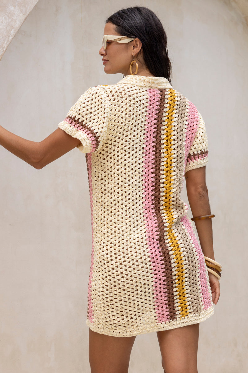 Hand crochet retro style button up shirt dress. Cream colour base with 70s vintage stripes in pink, mustard, mulberry and beige. Vertical stripes on one side and horizonatal stripes on the other side. 70s style collar and coconut buttons brings retro chic vibes. Back view has vertical stripes on one side.