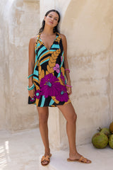 Large scale retro palm print flowy summer mini dress with v neckline that can also tie up to halter neck 100% rayon black magenta and aqua colourway with colourful bangles to compliment