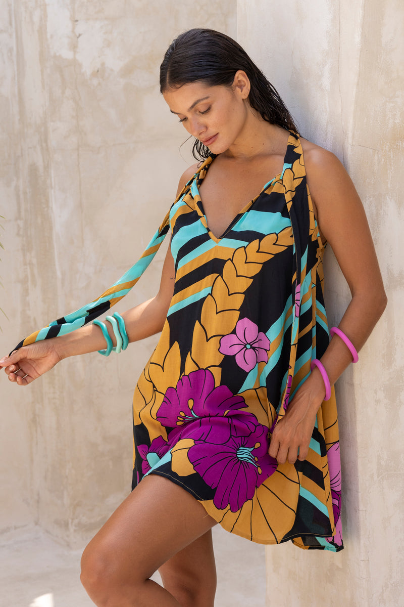 Large scale retro palm print flowy summer mini dress with v neckline that can also tie up to halter neck 100% rayon black magenta and aqua colourway with colourful bangles to compliment