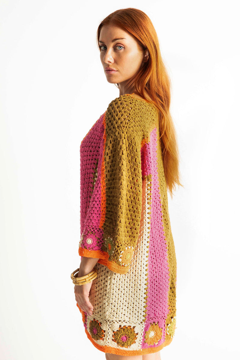 Boho style hand crocheted smock dress with 3/4 wide sleeves, featuring bold, pistachio, pink, orange and cream stripe sections and floral crochet details on the arms and hem. Made in 100% cotton