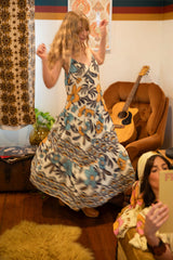 V-neck bohemian style floaty maxi dress with a low v-back and double layered frills in a large scale floral print in blues and mustard with a cream background