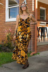 V-neck bohemian style floaty maxi dress with a low v-back and double layered frills in a large scale floral print in brown and gold tones with a black background