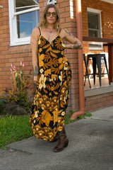 V-neck bohemian style floaty maxi dress with a low v-back and double layered frills in a large scale floral print in brown and gold tones with a black background