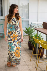Bold floral vintage style maxi dress in a soft rayon voile with high bateau neckline and retro  large scale blues and mustard flowers on a cream background