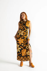 Bold floral vintage style maxi dress in a soft rayon voile with high bateau neckline and retro large scale brown and gold tone flowers on a black background
