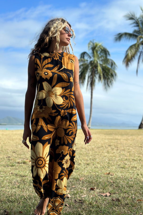 Bold floral vintage style maxi dress in a soft rayon voile with high bateau neckline and retro large scale brown and gold tone flowers on a black background