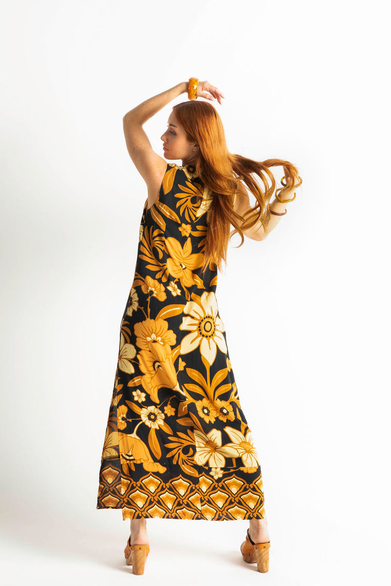 Bold floral vintage style maxi dress in a soft rayon voile with high bateau neckline and retro large scale brown and gold tone flowers on a black background