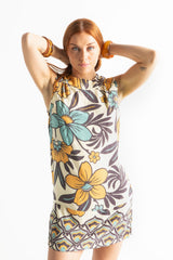 Bold floral vintage style mini dress in a soft rayon voile with high bateau neckline and retro  large scale blues and mustard flowers on a cream background