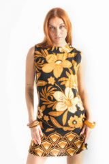 Bold floral vintage style mini dress in a soft rayon voile with high bateau neckline and retro  large scale brown and gold tone flowers on a black background