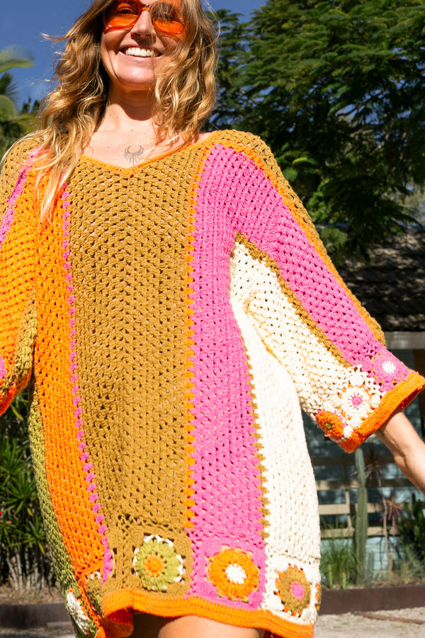 Boho style hand crocheted smock dress with 3/4 wide sleeves, featuring bold, pistachio, pink, orange and cream stripe sections and floral crochet details on the arms and hem. Made in 100% cotton
