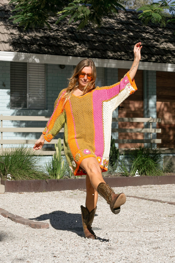 Boho style hand crocheted smock dress with 3/4 wide sleeves, featuring bold, pistachio, pink, orange and cream stripe sections and floral crochet details on the arms and hem. Made in 100% cotton