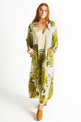 70s inspired maxi kaftan-style dress with bell sleeves , retro patch pockets and a v-neckline. Features a bold, large-scale  retro geo print. in rich green tones. Made in 100% cotton