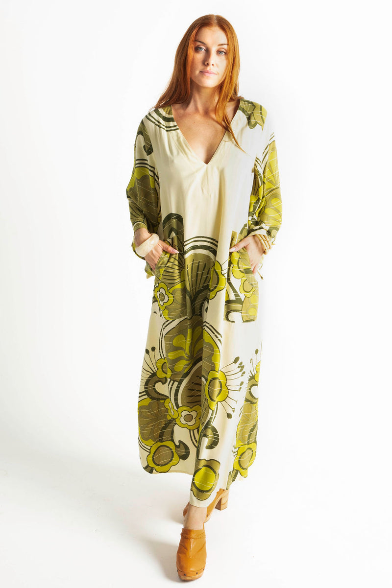 70s inspired maxi kaftan-style dress with bell sleeves , retro patch pockets and a v-neckline. Features a bold, large-scale  retro geo print. in rich green tones. Made in 100% cotton