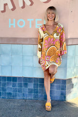 60s inspired mini smock dress with bell sleeves and a v-neckline. Features a bold, large-scale tangerine, pink and brown retro geo print. Made in 100% cotton