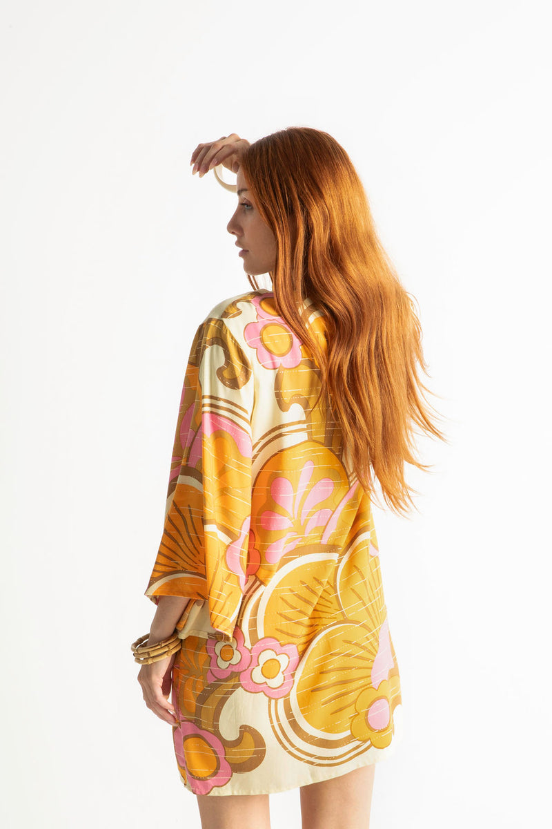 60s inspired mini smock dress with bell sleeves and a v-neckline. Features a bold, large-scale tangerine, pink and brown retro geo print. Made in 100% cotton