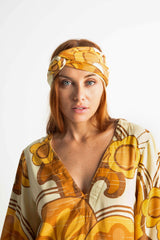 Versatile wrap that an be styled as a head wrap, scarf, wrap around top or belt to add that vintage-chic flair to any outfit. Made in 100% rayon in a rich mustard and cream, bold large scale retro print