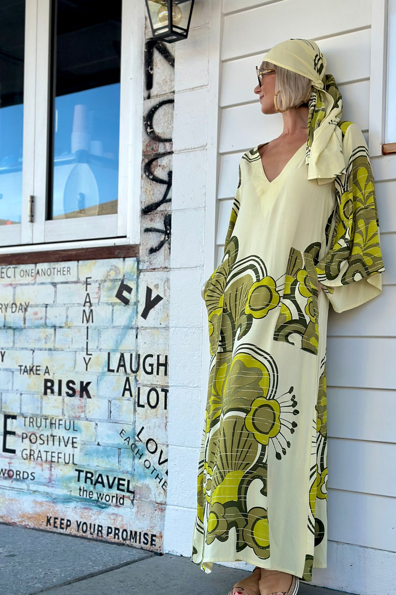 70s inspired maxi kaftan-style dress with bell sleeves , retro patch pockets and a v-neckline. Features a bold, large-scale  retro geo print. in rich green tones. Made in 100% cotton