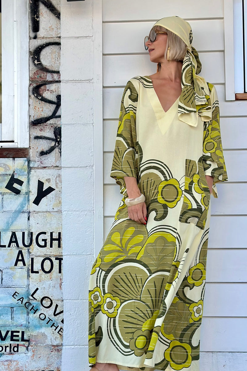 70s inspired maxi kaftan-style dress with bell sleeves , retro patch pockets and a v-neckline. Features a bold, large-scale  retro geo print. in rich green tones. Made in 100% cotton