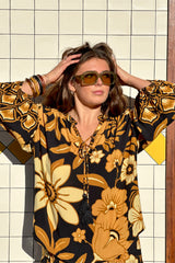 Vintage inspired bohemian blouse with a v- neckline and tie details in a large scale floral print in brown and gold tones with a black background