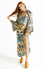 70s vintage inspired boho midi dress with bold retro floral print in blue,tan and navy on a cream background, bell sleeves and side splits. Made in rayon