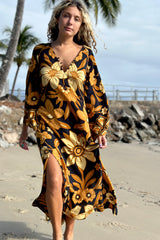 70s vintage inspired boho midi dress with bold retro floral print in brown,gold and cream tones on a black background, bell sleeves and side splits. Made in rayon