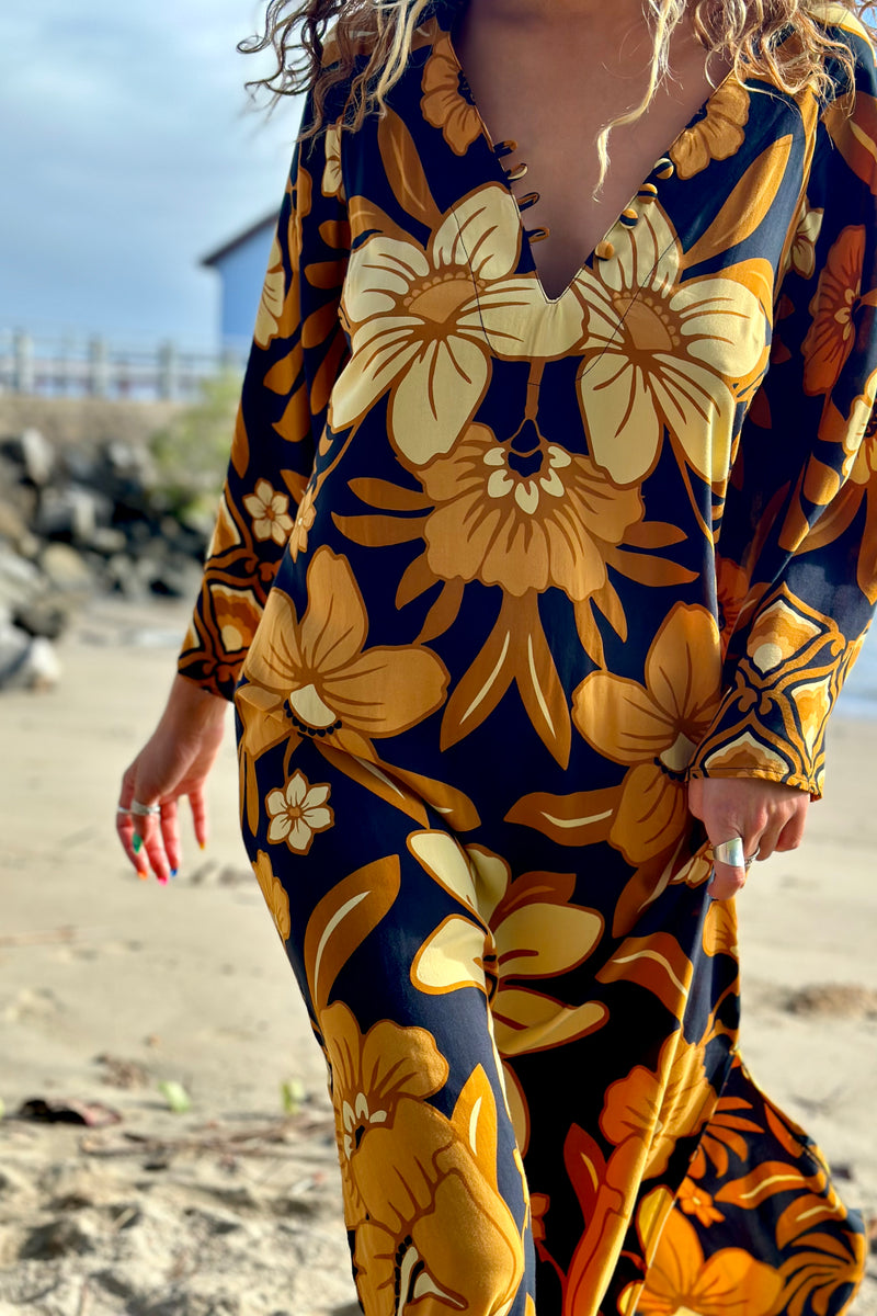 70s vintage inspired boho midi dress with bold retro floral print in brown,gold and cream tones on a black background, bell sleeves and side splits. Made in rayon