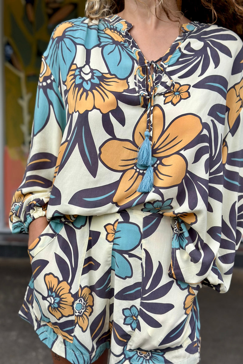 Vintage inspired high waist shorts with patch pockets  in a large scale floral print in blues and mustard with a cream  background