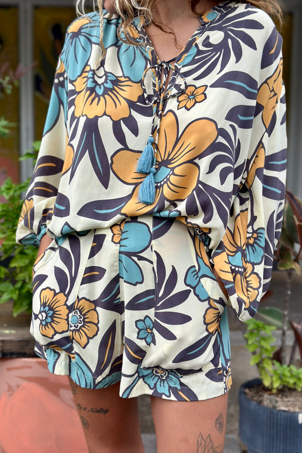 Vintage inspired high waist shorts with patch pockets  in a large scale floral print in blues and mustard with a cream  background